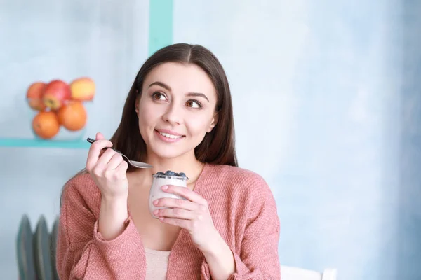 家でおいしいヨーグルトを食べる若い女性 — ストック写真