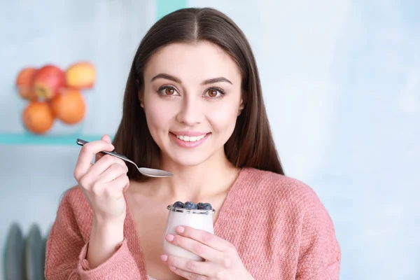 Genç kadın lezzetli yoğurt evde yemek — Stok fotoğraf