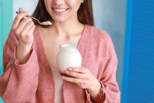 Young woman eating tasty yogurt at home, closeup — Stock Photo, Image