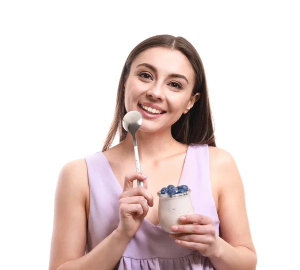 Молодая женщина ест вкусный йогурт на белом фоне — стоковое фото