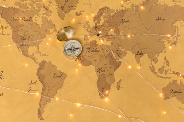 Bússola com guirlanda no mapa do mundo — Fotografia de Stock