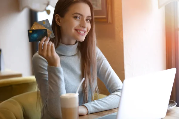 Young woman with credit cards shopping online in cafe — Stock Photo, Image