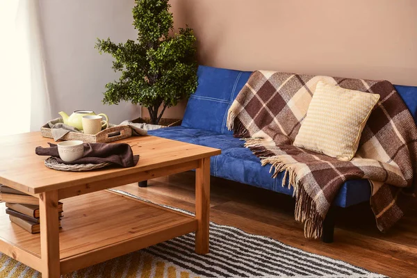Interiér obývacího pokoje s elegantní modrou sedačkou a dřevěný stůl — Stock fotografie