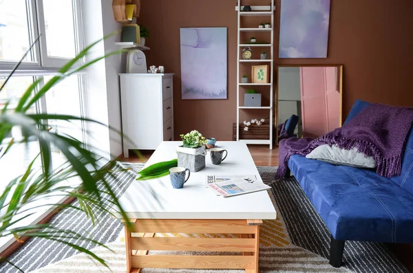 Interno del soggiorno con elegante divano blu e tavolo in legno — Foto Stock