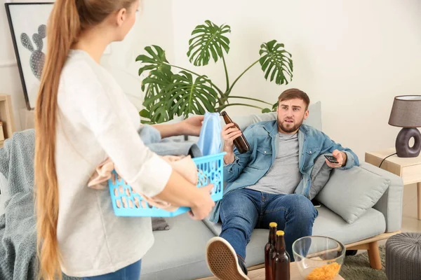 Housewife scolding her lazy husband resting on couch — Stock Photo, Image