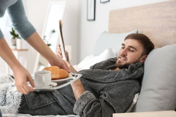 Дружина приносить їй лінивий чоловік сніданок у ліжку — стокове фото