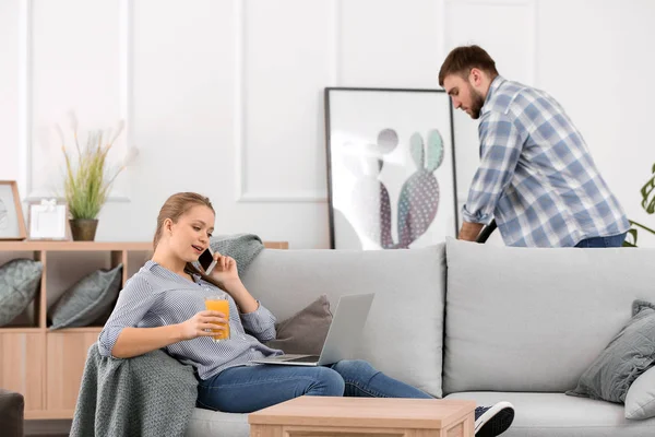 Househusband cleaning floor while his wife working at home — Stock Photo, Image
