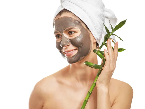 Vrouw met gezichtsmasker en bamboe tak op witte achtergrond — Stockfoto