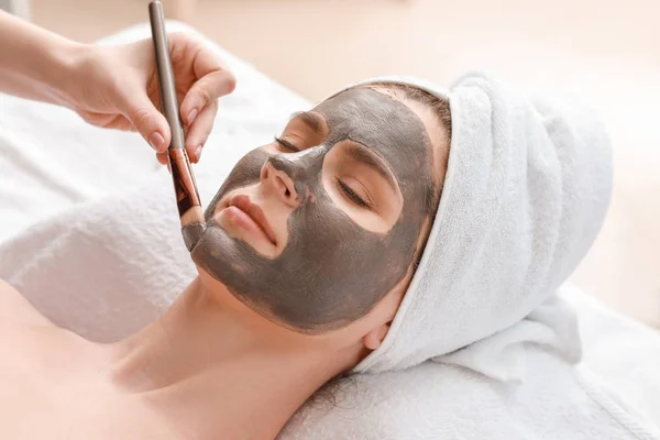 Cosmetologist applying mask onto face of woman in beauty salon — Stock Photo, Image
