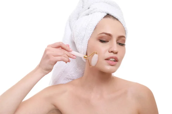 Mujer joven con herramienta de masaje facial sobre fondo blanco — Foto de Stock