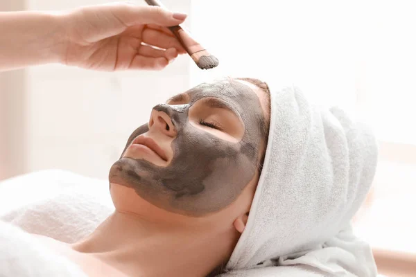 Cosmetologist aplicando máscara no rosto da mulher no salão de beleza — Fotografia de Stock