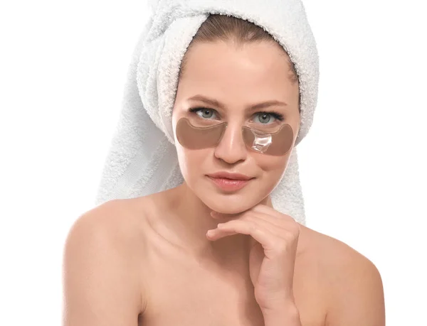 Young woman with under-eye patches on white background — Stock Photo, Image