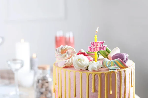Tasty cake with burning candle on light background