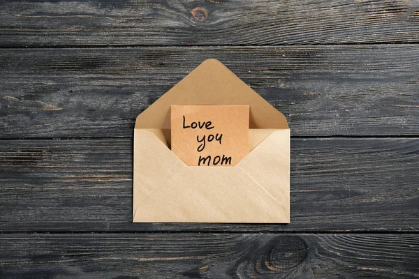 Envelope with greeting card for Mother's Day on wooden background — Stock Photo, Image