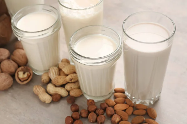 Assortment of tasty vegan milk on grey table — Stock Photo, Image