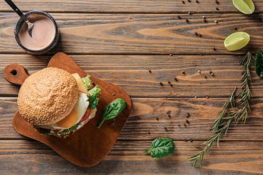 Ahşap masada sos ile lezzetli burger