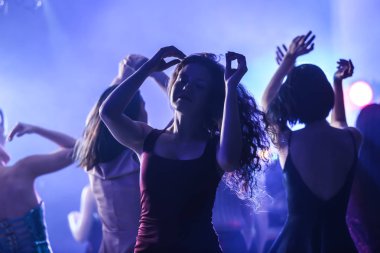 Gece kulübünde dans eden güzel genç kadınlar.