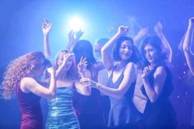 Gece kulübünde dans eden güzel genç kadınlar.
