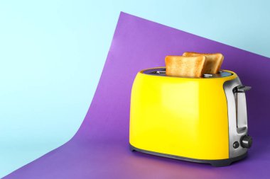 Renk arka planda ekmek dilimleri ile tost makinesi