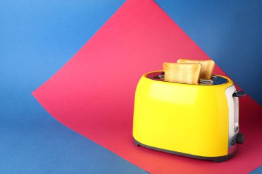 Renk arka planda ekmek dilimleri ile tost makinesi