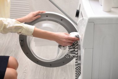 Evde çamaşır yıkayan bir kadın.