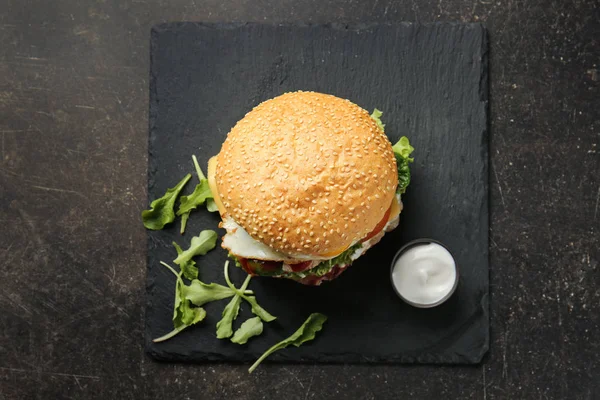 Tasty burger on dark table — Stock Photo, Image
