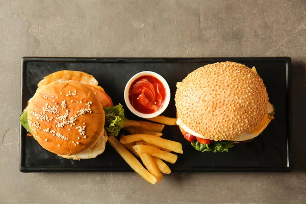 Tasty burgers with french fries and sauce on plate — Stock Photo, Image