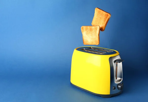 Toaster with bread slices on color background — Stock Photo, Image