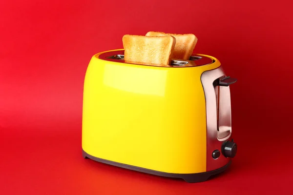Toaster with bread slices on color background — Stock Photo, Image