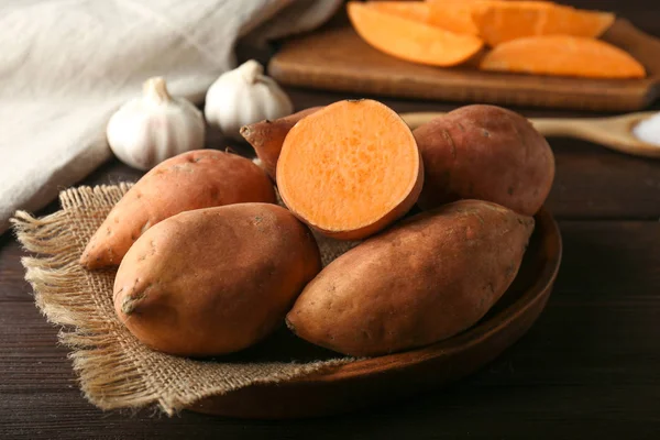 Raw sweet potato on wooden table — Stock Photo, Image