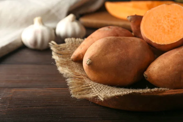 Raw sweet potato on wooden table — Stock Photo, Image
