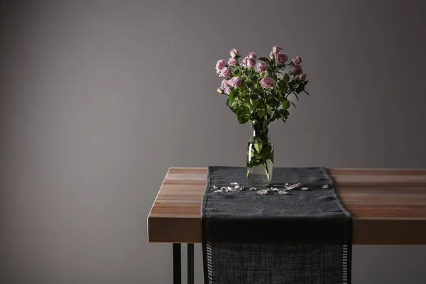 灰色の背景に対してテーブルに美しいバラの花と花瓶 — ストック写真