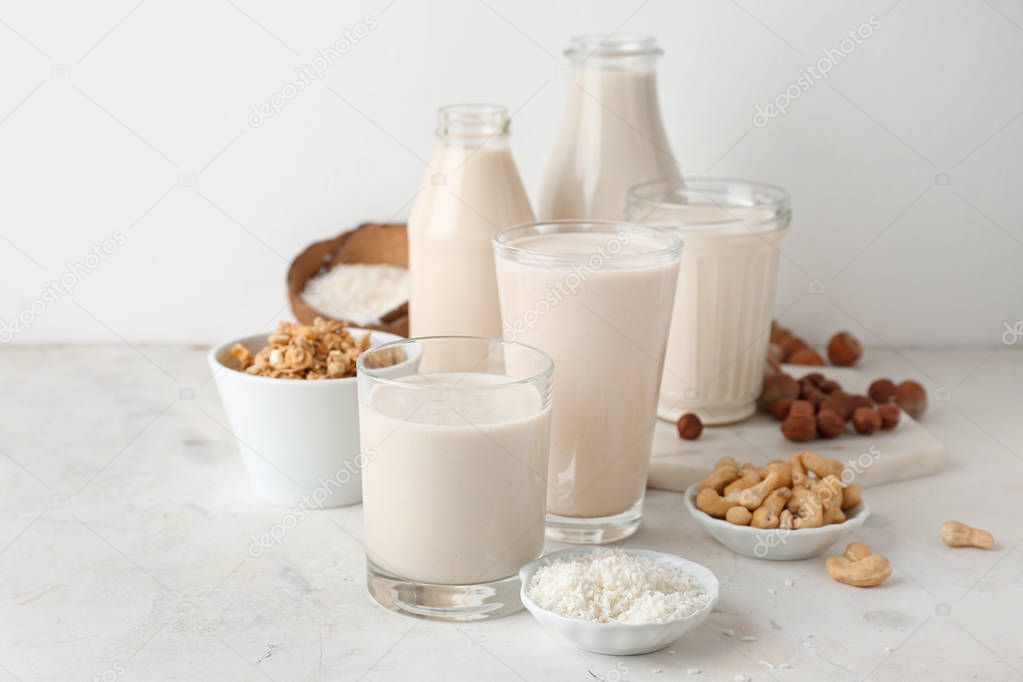 Assortment of tasty vegan milk on light table