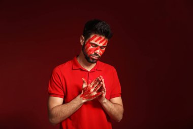 Onun yüzünü ve ellerini renk arka plan üzerinde boya ile yakışıklı adam portresi