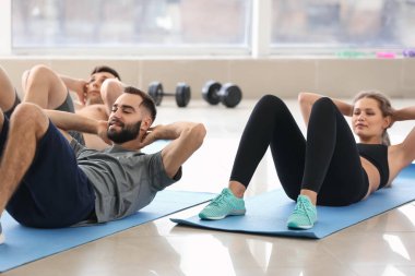 Spor salonunda egzersizi yapıyor sportif gençler