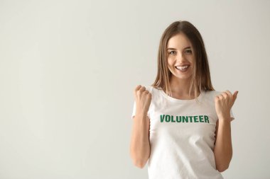 Mutlu genç kadın gönüllü ışık arka plan üzerinde