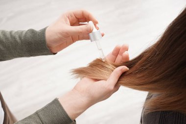 Serum saç salonda genç kadının üzerine uygulayarak Kuaför