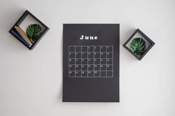Black calendar hanging on light wall — Stock Photo, Image