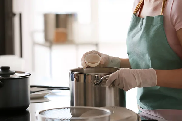 Kvinna som förbereder läckra ost i köket — Stockfoto