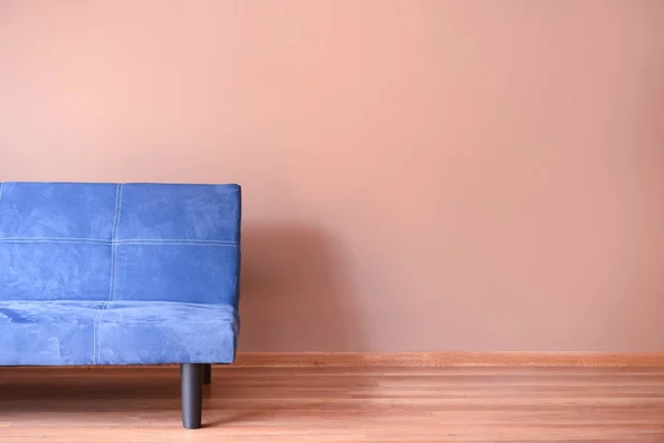 Sofá azul elegante perto da parede de cor no quarto — Fotografia de Stock