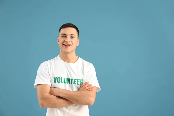 Young male volunteer on color background — Stock Photo, Image