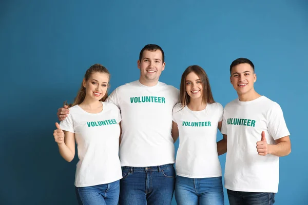 Team of young volunteers on color background — Stock Photo, Image