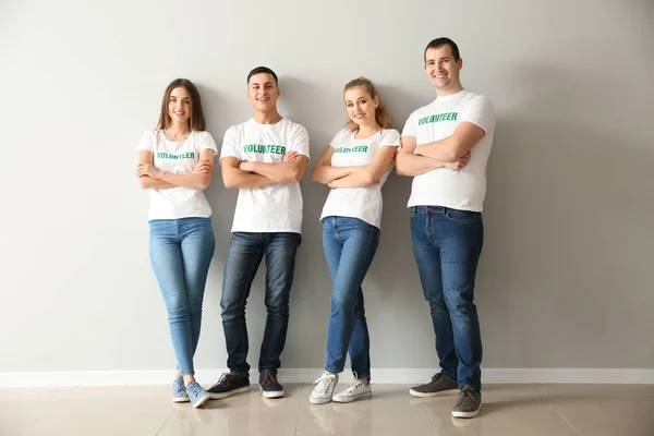 Equipo de jóvenes voluntarios cerca de la pared de luz — Foto de Stock