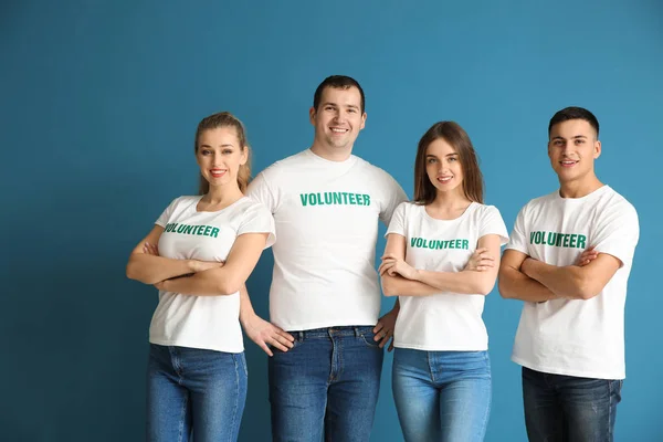 Equipo de jóvenes voluntarios sobre fondo de color — Foto de Stock