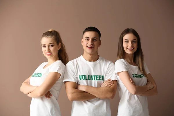 Team of young volunteers on color background — Stock Photo, Image