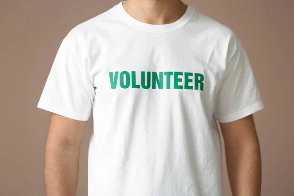 Młody mężczyzna wolontariuszy na kolor tła — Zdjęcie stockowe