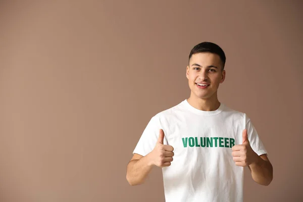 Młody mężczyzna wyświetlone wolontariuszy kciuk na kolor tła — Zdjęcie stockowe