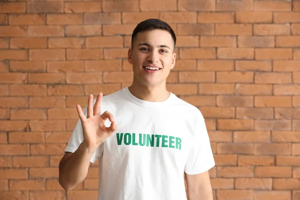 Tamam duvara karşı gösterilen genç erkek gönüllü — Stok fotoğraf