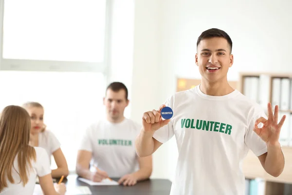 Joven voluntario masculino en la reunión en interiores — Foto de Stock