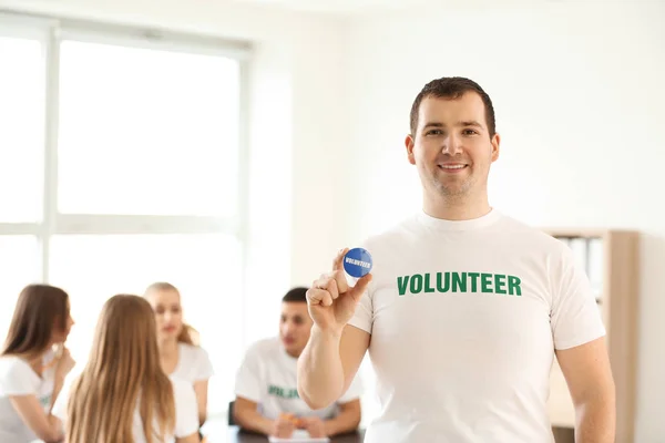 Young male volunteer at meeting indoors — Stock Photo, Image